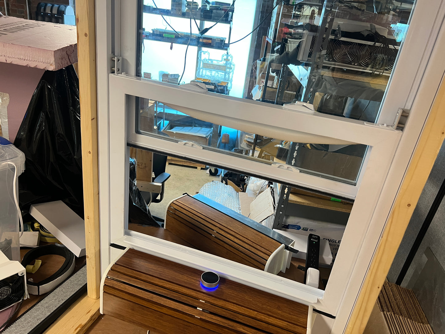 Open window showing indoor setting with furniture and equipment.