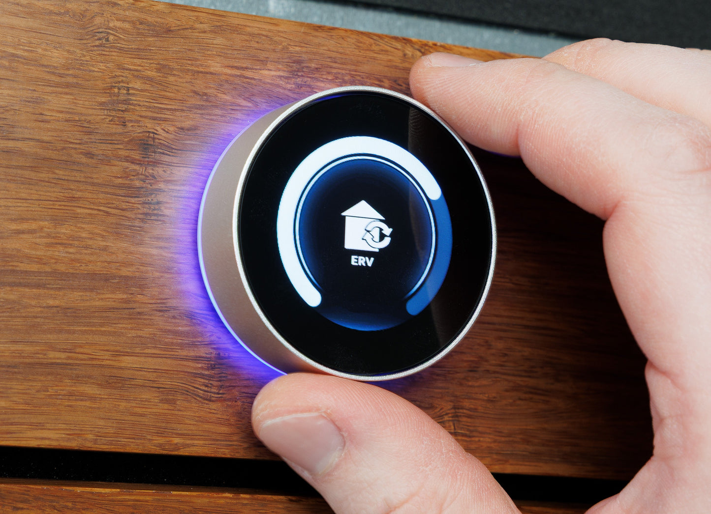 Hand pressing a button on a wooden panel with a digital display