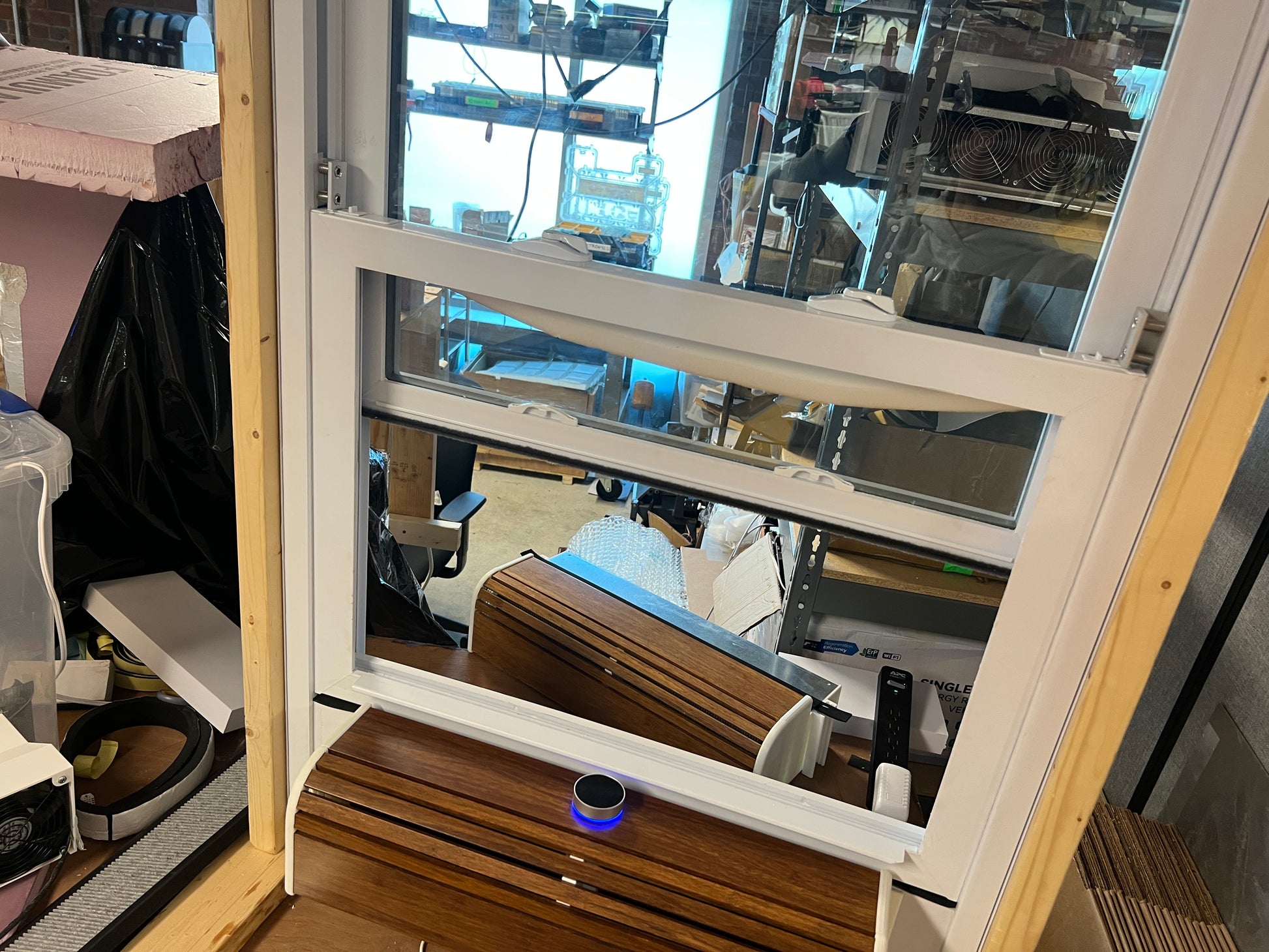 Open window showing indoor setting with furniture and equipment.